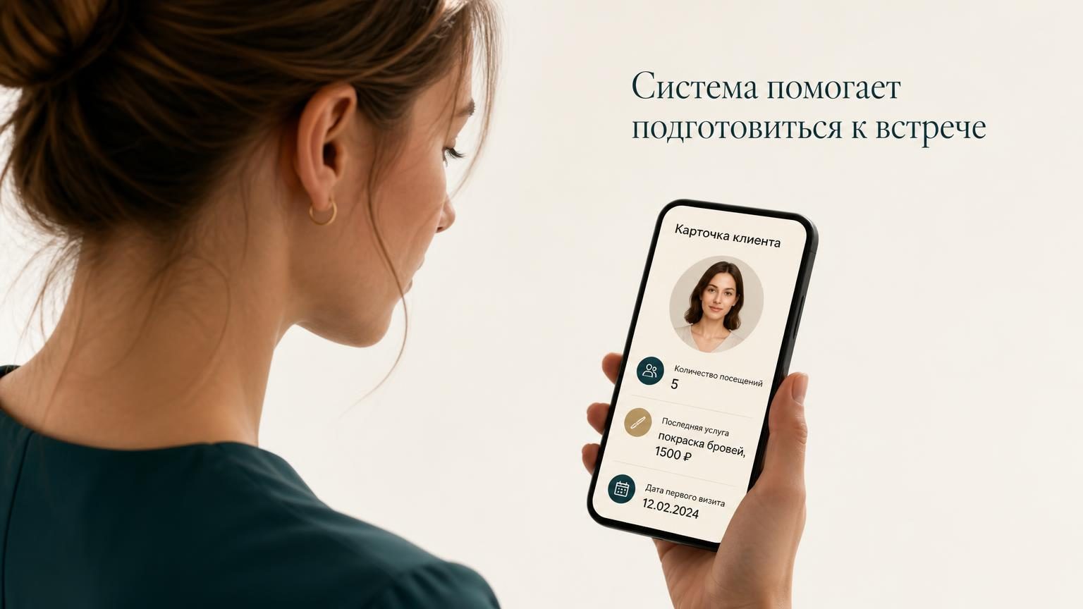 На экране мобильного телефона видна карточка клиента: фото профиля, количество посещений (5), последняя услуга (покраска бровей, 1500 ₽), дата первого визита. Мастер смотрит на …